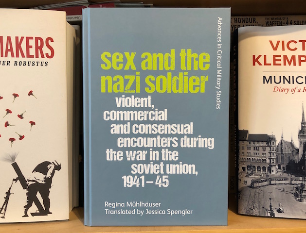 The cover of the book Sex and the Nazi Soldier on a bookshelf with other books I've translated